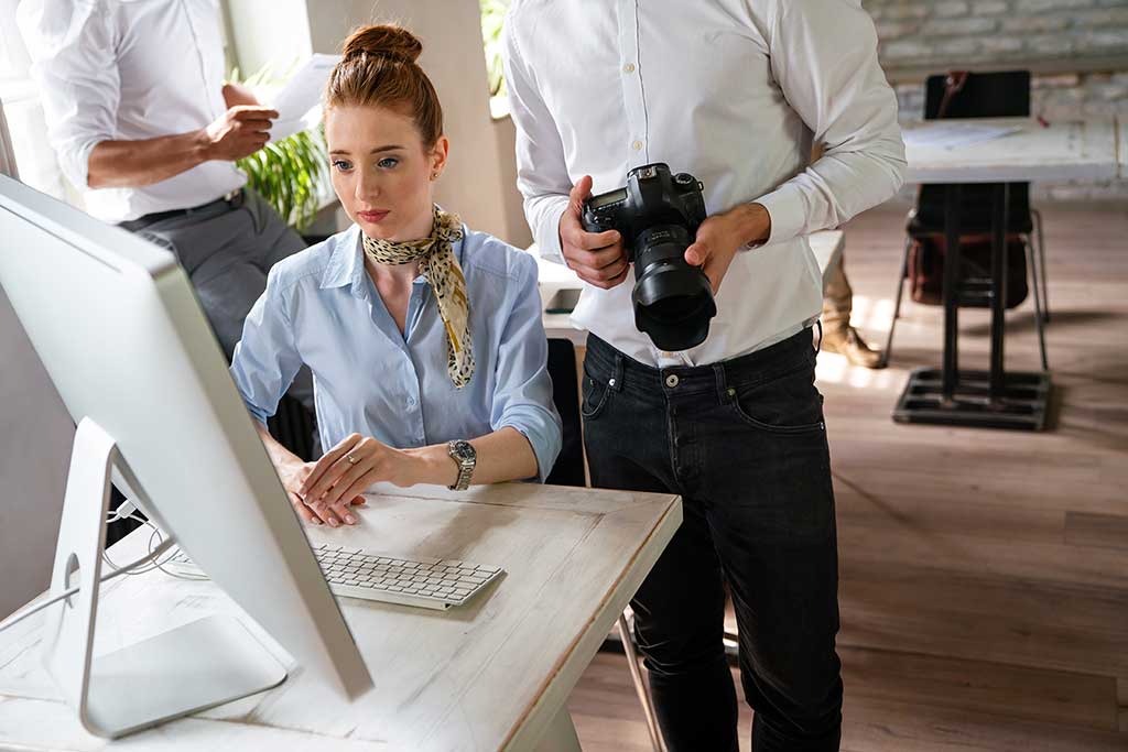 Woman editing photographs on a computer using professional photo editing software at OcalaCode.com.