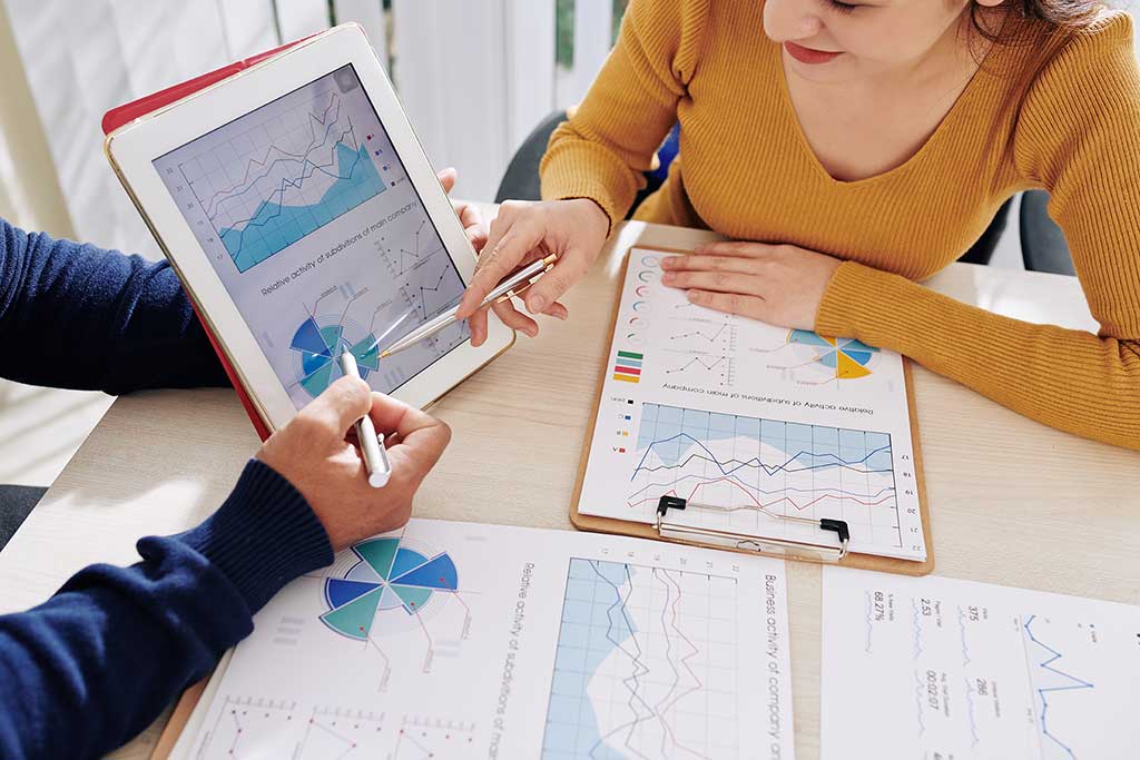 Woman analyzing customer relationship management (CRM) software from OcalaCode.com on a desktop computer screen.