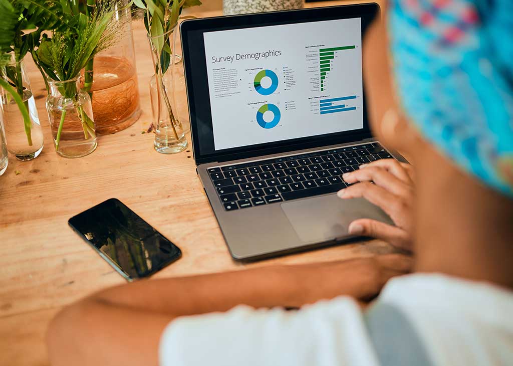 Woman analyzing SEO statistics and website performance metrics on a laptop screen.